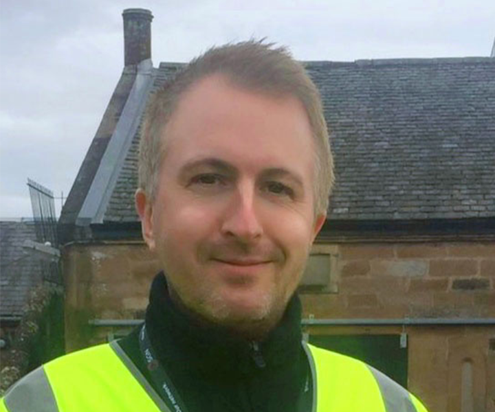 Photo of Jon Gibson, a SGN First Call Operative. The photo shows Jon at work wearing a high-visibility jacket