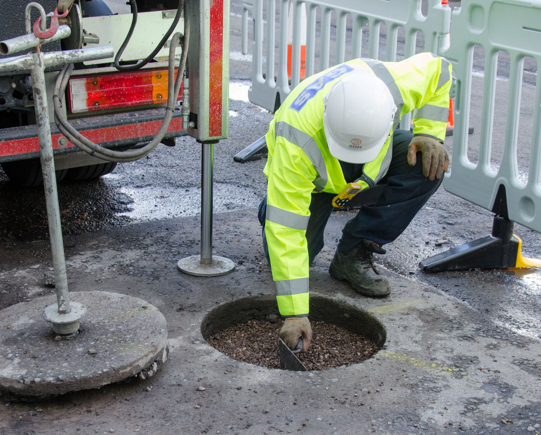 Gas engineer restoring road surface following core and vac