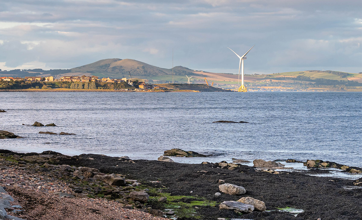 View of Levenmouth in Fife, home to SGN's H100 Fife hydrogen project, with offshore wind turbine across the bay.