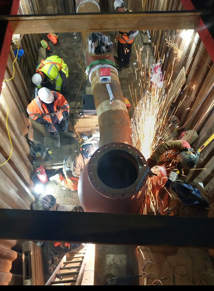 Engineers working on a pipe