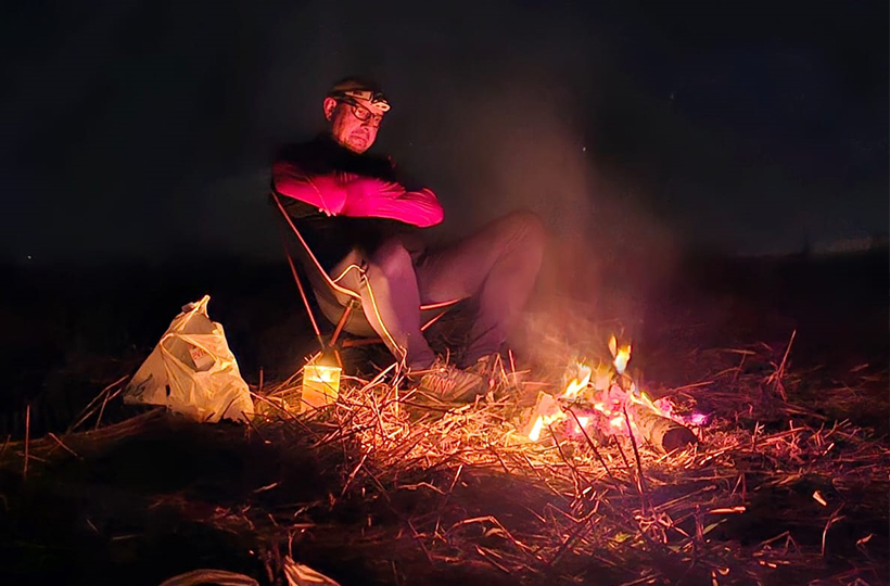 A man sat at a campfire