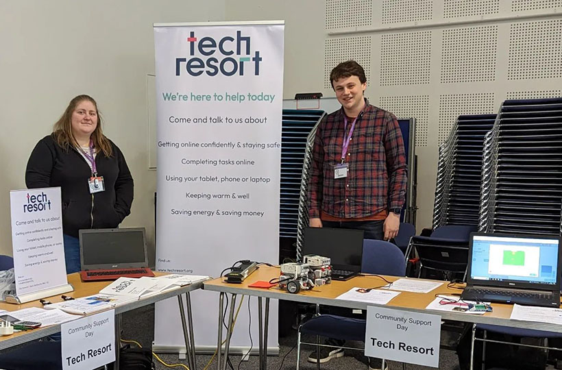 Two representatives of Tech Resort standing behind desks at an event