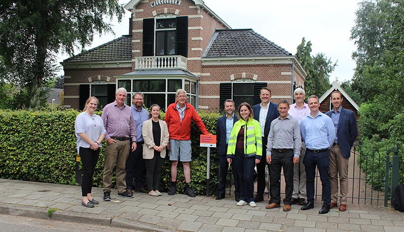 A group of people standing in front of a detached home