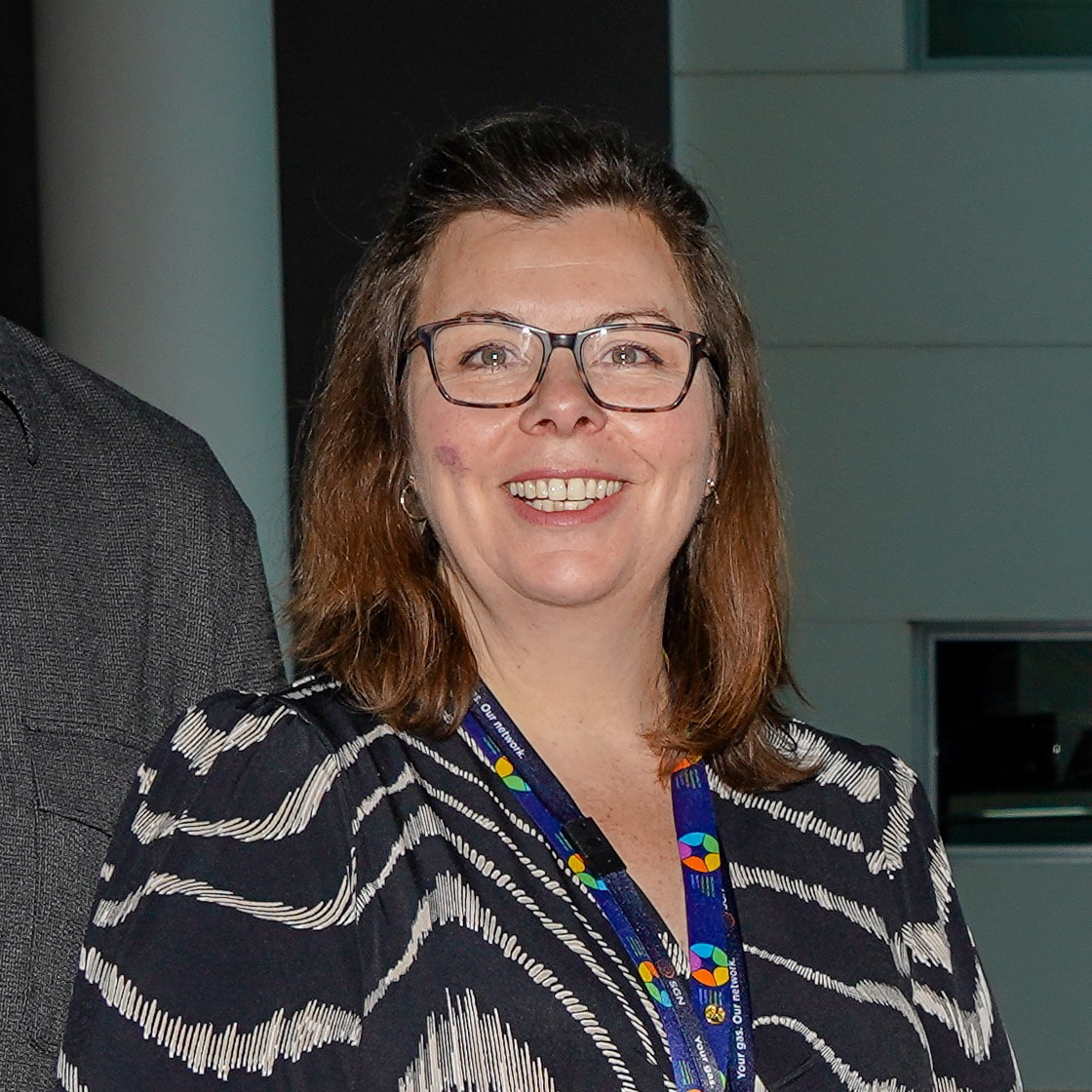 A woman with brown hair and glasses