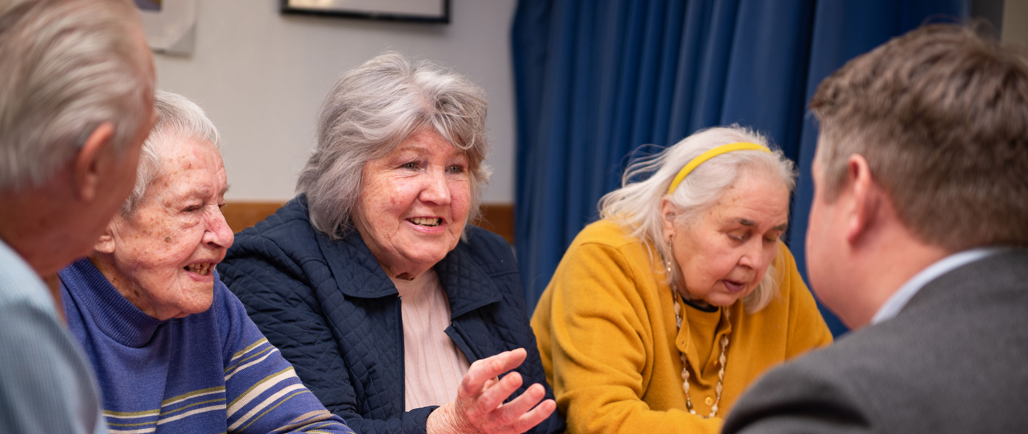 Image showing 3 elderly ladies talking to a man in a suit