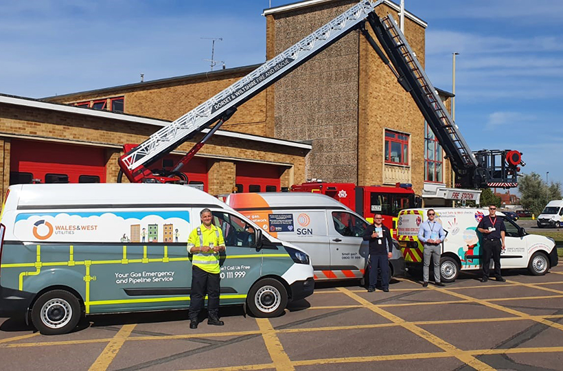 Three GDN vans and staff standing outside a fire station