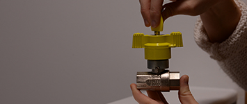 image showing a yellow locking cooker valve held in two hands and demonstrating how it works
