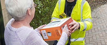 SGN engineer in hi vis handing electric heater to a customer