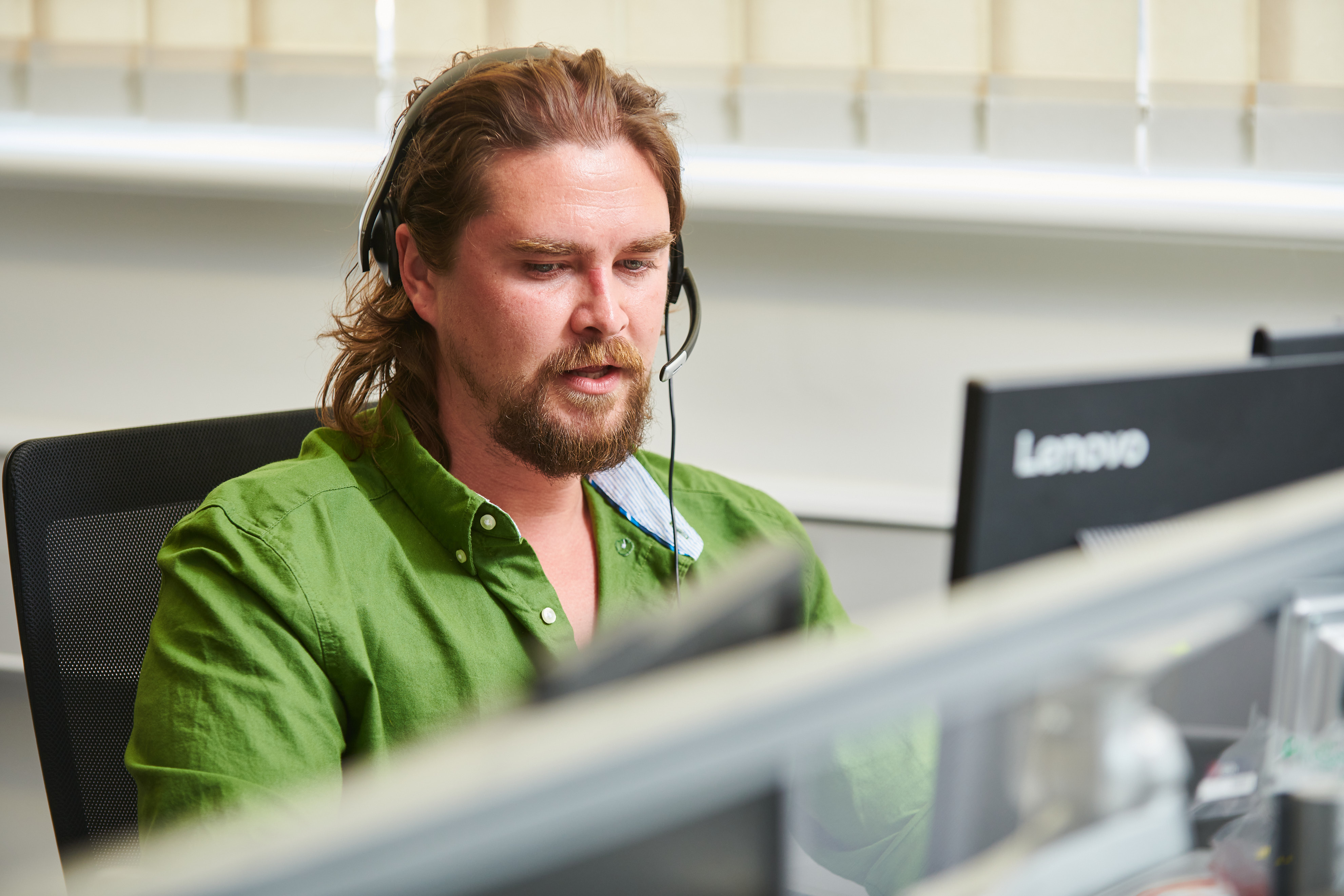 A man wearing a headset in a call centre