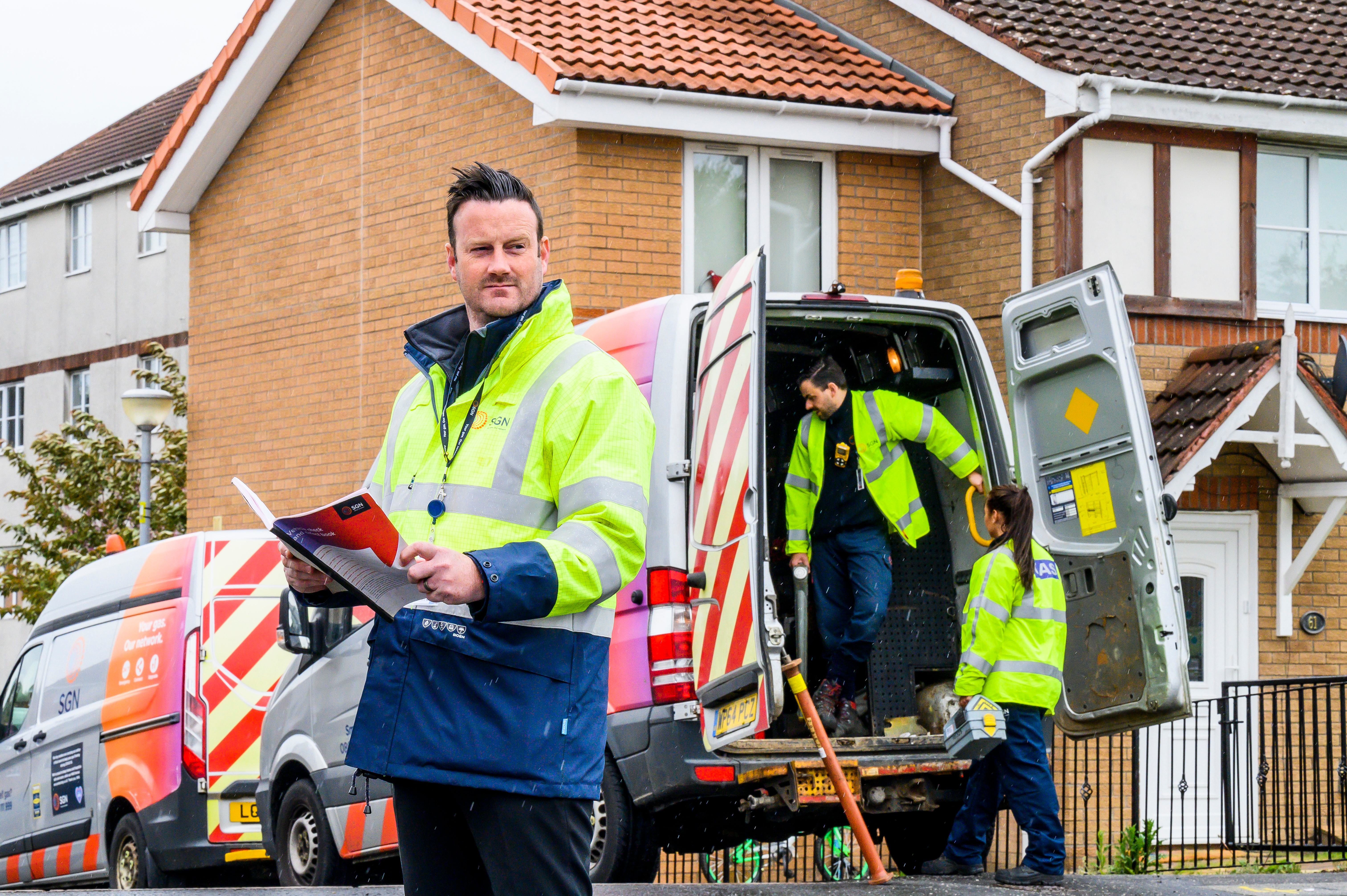 SGN engineers next to an SGN van on a residential street