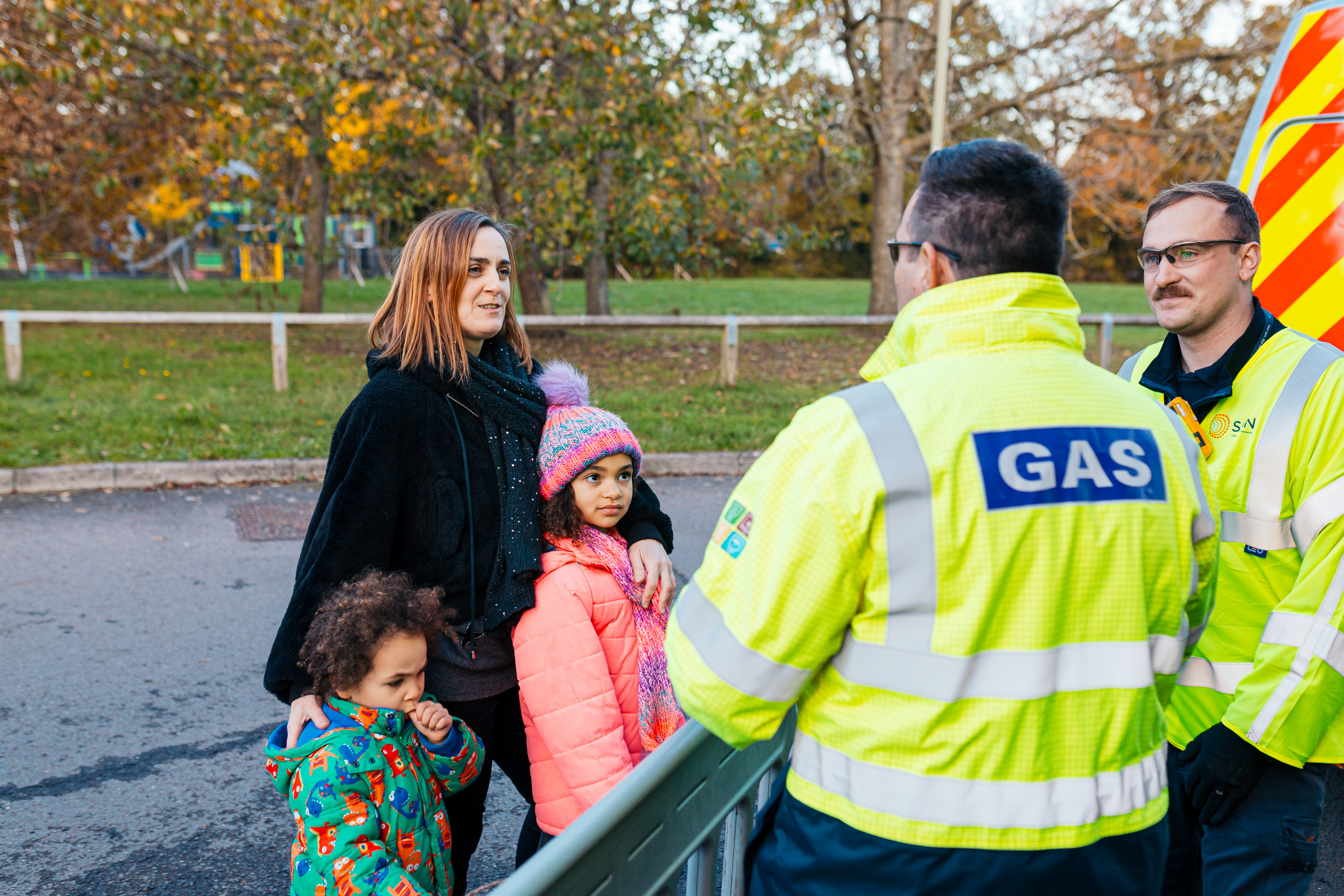 SGN engineers talking with a young family next to a park