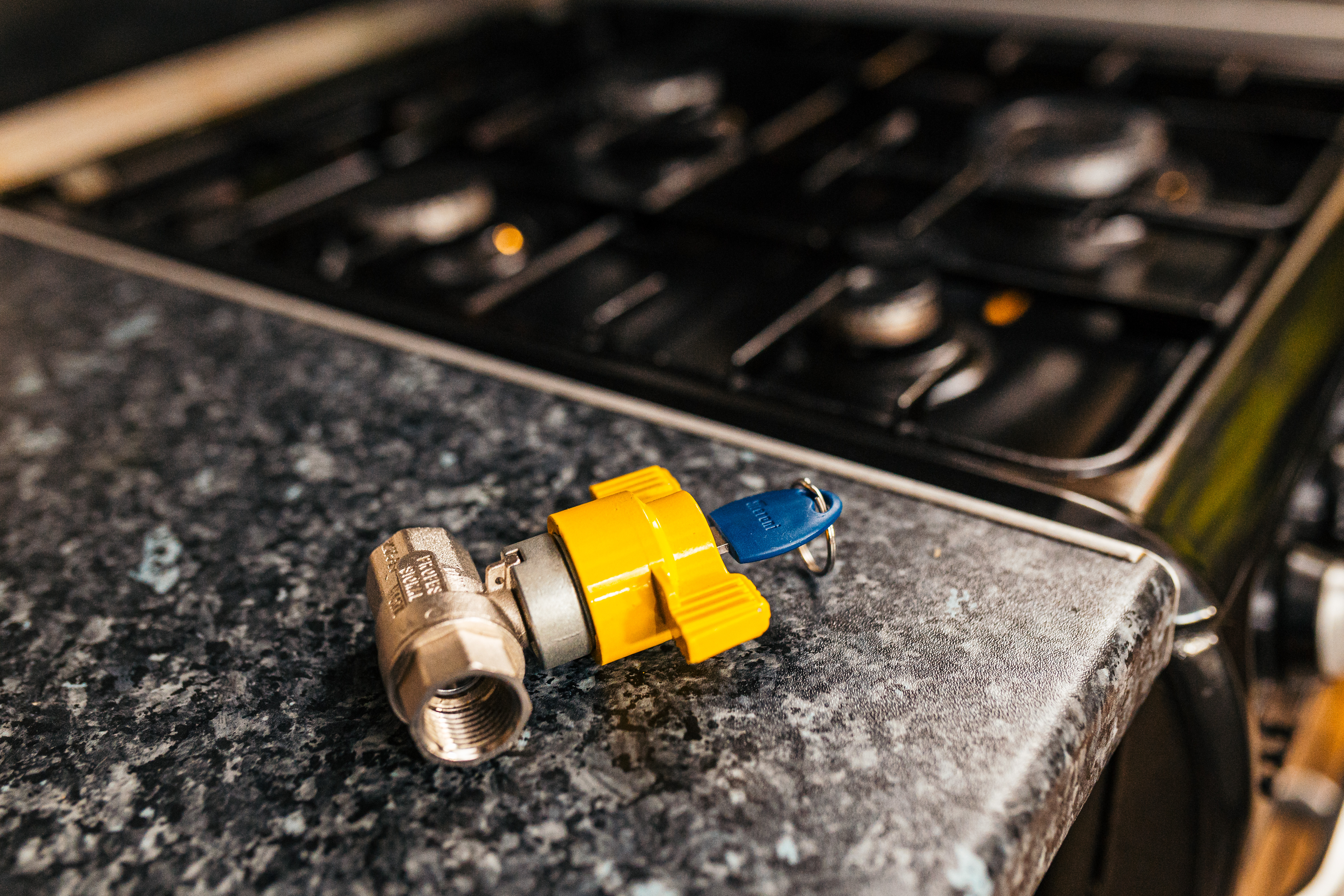 A locking cooker valve on a kitchen side next to a cooker hob