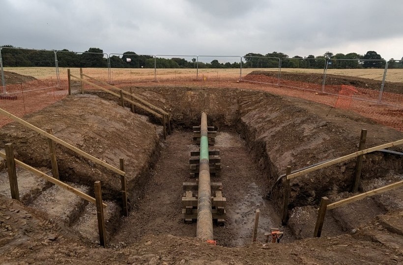 High pressure pipeline in a Scottish field, with the countryside landscape all around.