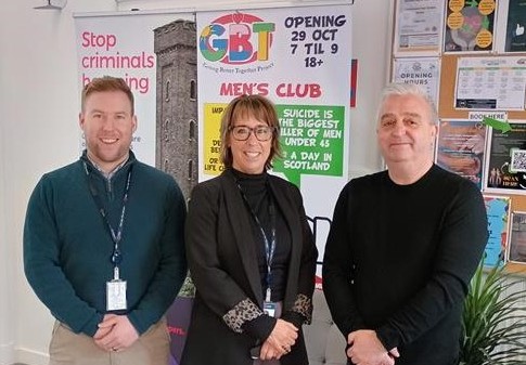 The project team are standing in front of a pop-up banner explaining the Shotts Healthy Living initiative