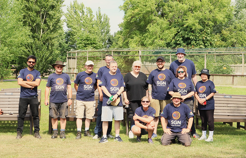 A group of smiling people stood in the sunshine