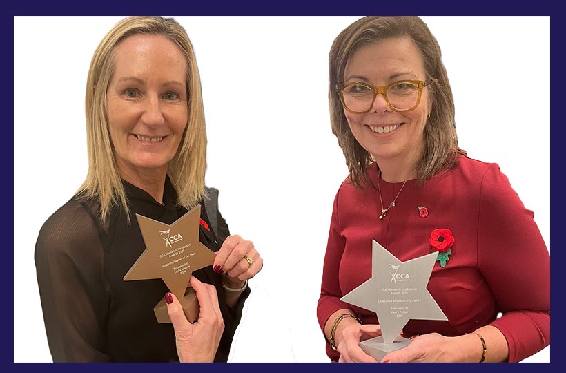 Two women holding award trophies
