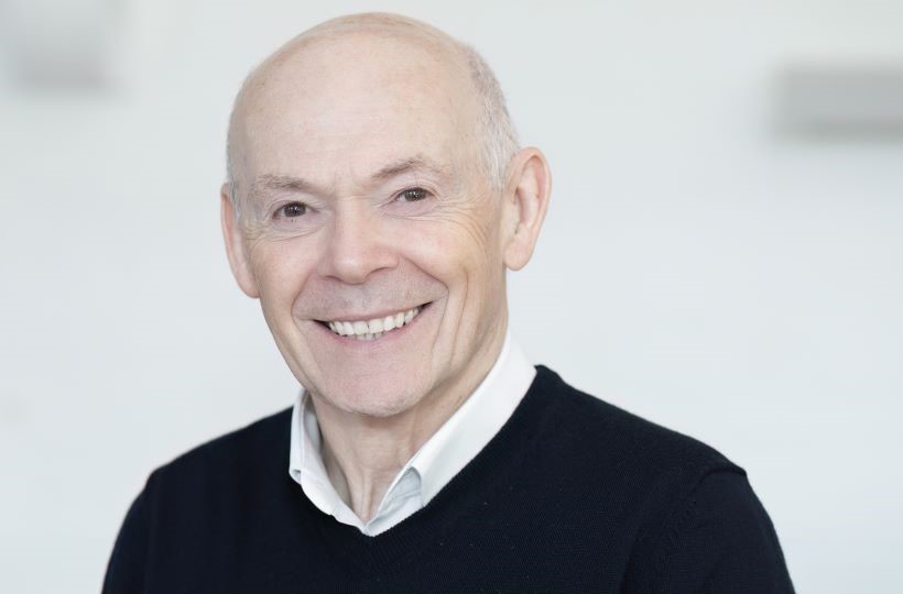 Head and shoulders image of Chris Murray, an older gentleman, wearing jumper and shirt. He is smiling.