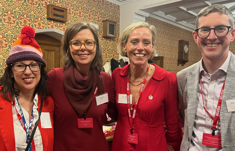 Four people in smart clothes smiling for the camera