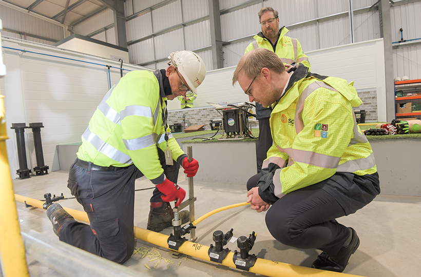 Two engineers working on a gas pipe