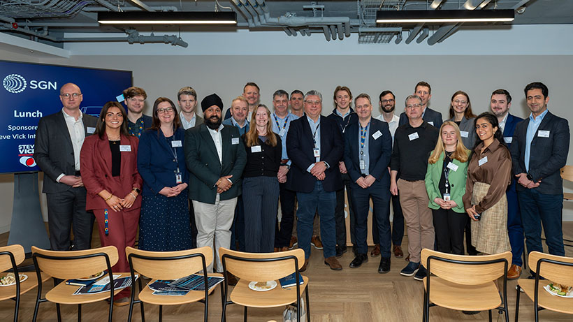 Line-up for Showcase Innovation Event. Various men and women in business attire standing for a group photo.