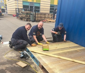 SGN volunteers work on a new dancing stage as part of the CAP project at Tayview Primary School