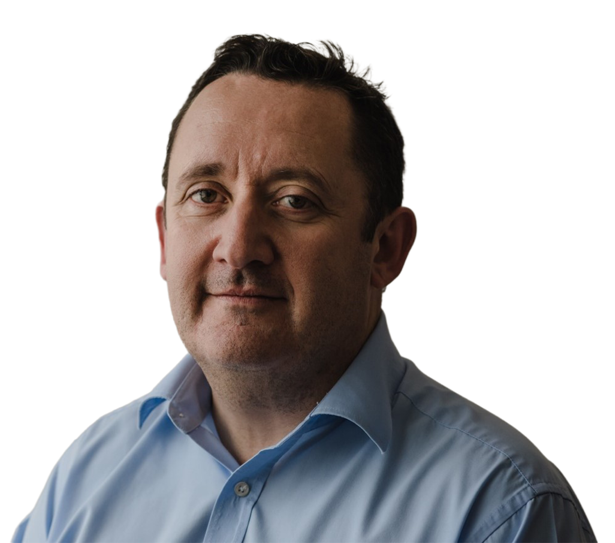A selfie of a white man looking at the camera against a blank background