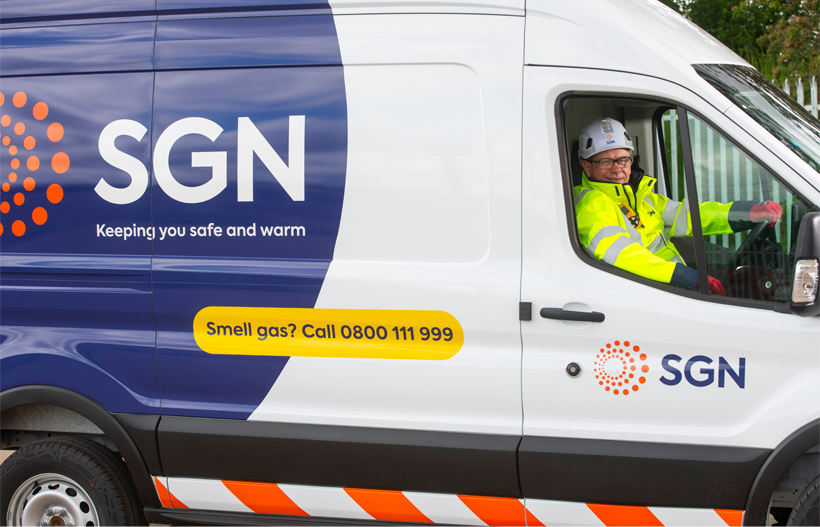 An SGN van with an engineer in PPE in the driver's seat, smiling out of the window