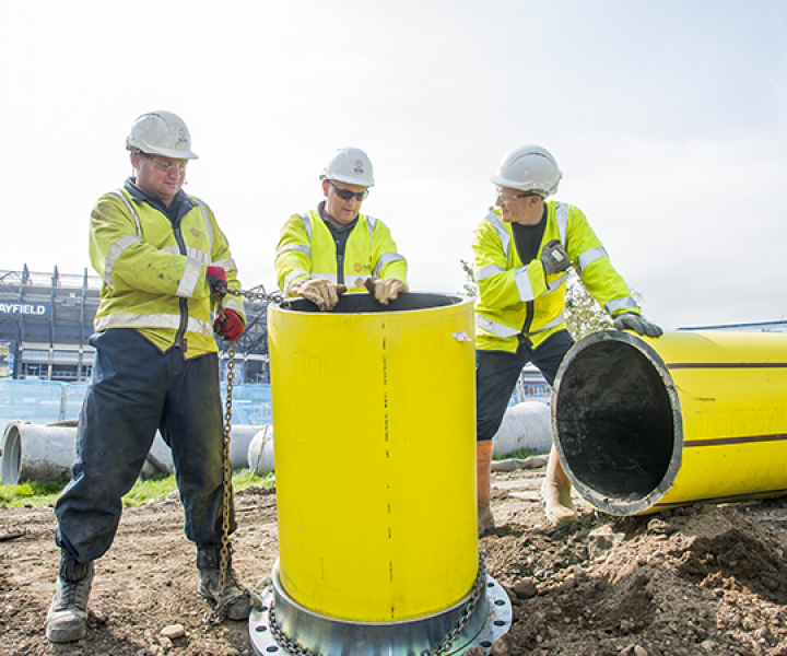 Our engineers standing in front of a large gas pipe