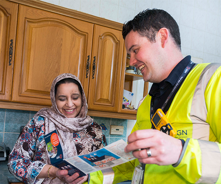 A SGN engineer shows a leaflet to a customer