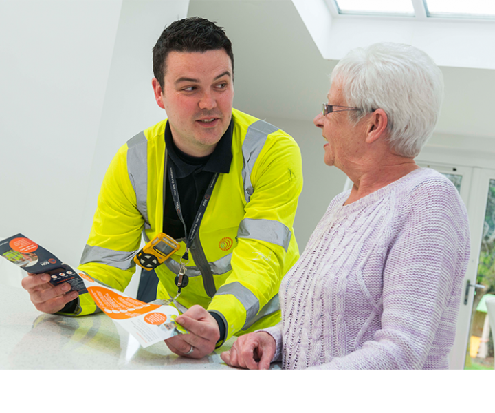 An engineer showing an SGN leaflet to a customer