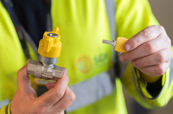 An engineer holding a locking cooker valve