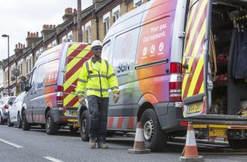 Gas engineer walking in road next to SGN vans