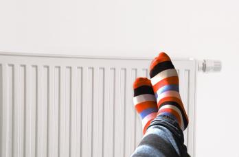 Feet wearing stripy socks resting on a warm radiator