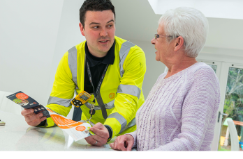 An engineer showing an SGN leaflet to a customer