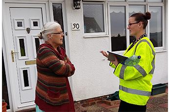 Polly wearing her personal protective clothing talks to a customer on site