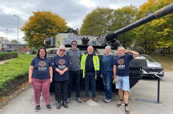 SGN volunteers stand in front of a military tank at Aldershot's military museum