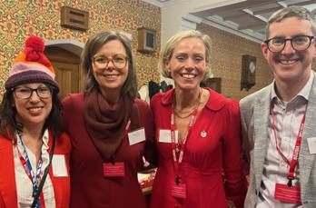 Four people in smart clothes smiling for the camera