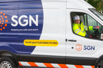 An SGN van with an engineer in PPE in the driver's seat, smiling out of the window